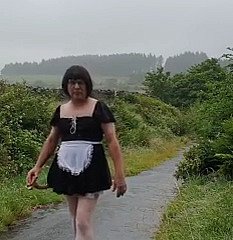 Femme de ménage travestie dans une voie publique sous sneezles pluie